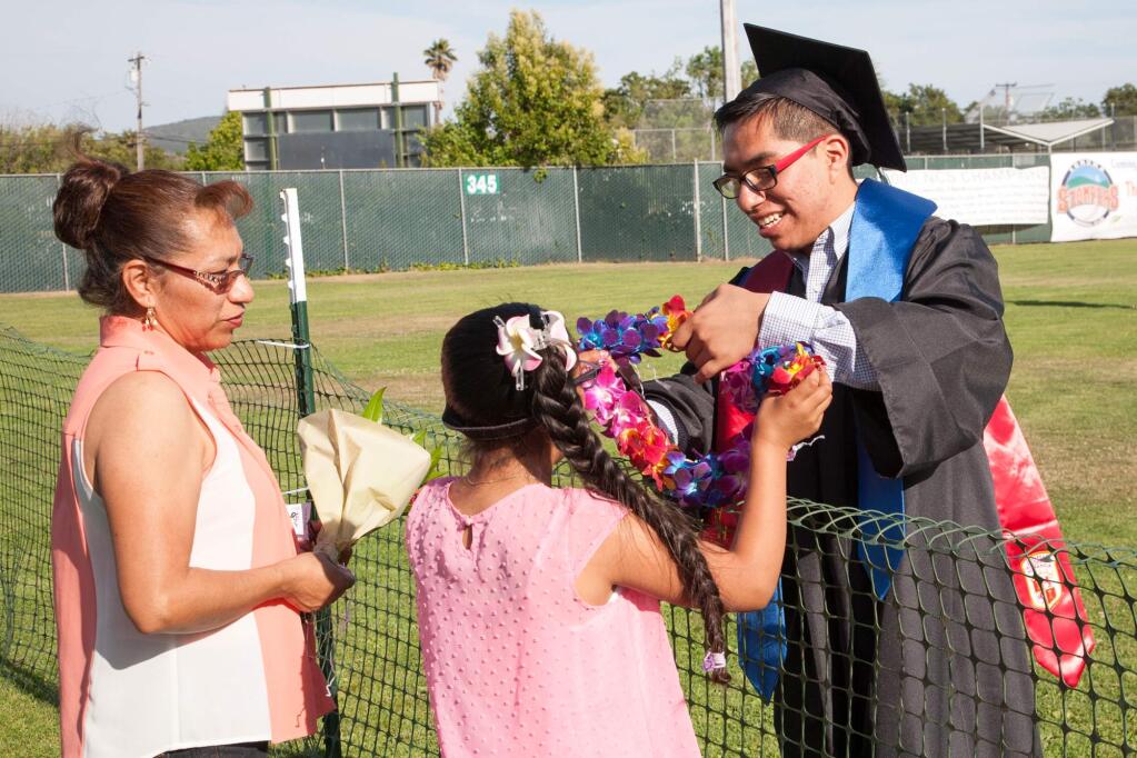 Gabriel Rendon accepts a flower lei from his mother, Etelbina, and his sister, Andrea, before SVHS graduation ceremonies, 6/5/15, Arnold Field. (Julie Vader / Sonoma Index-Tribune)