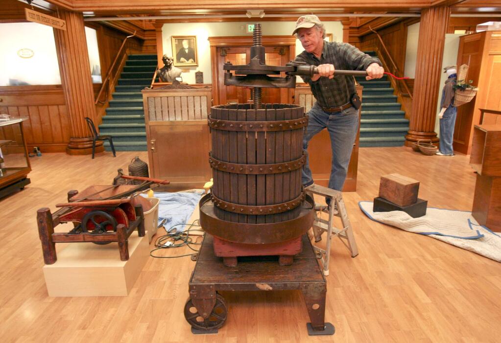 Jim McCormick, prorietor of the California Wine Museum, checks out a wine press as he works at instaling the upcoming exhibit, 'Petaluma Viticulture History & Heritage: A Celebration of Wine & Community' on Tuesday September 16, 2014.