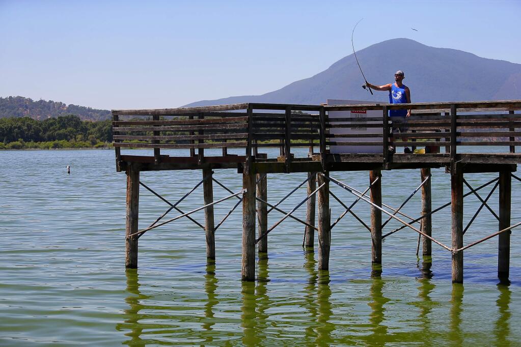 Johnnie Heal fishes from a pier in Clearlake Oaks, on Thursday, July 28, 2016. Heal only fishes for sport, and does not eat the fish that he catches due to mercury levels in the fish. (Christopher Chung/ The Press Democrat)