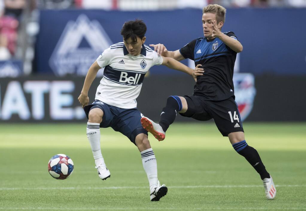 Vancouver Whitecaps' Inbeom Hwang, left, and San Jose Earthquakes' Jackson Yueill vie for the ball during the first half of an MLS soccer game, Saturday, July 20, 2019 in Vancouver, British Columbia. (Darryl Dyck/The Canadian Press via AP)
