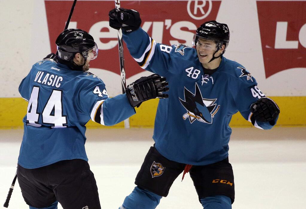 San Jose Sharks' Marc-Edouard Vlasic (44) celebrates with teammate Tomas Hertl (48) after Vlasic assisted on a goal by Ben Smith during the first period of an NHL hockey game Monday, March 2, 2015, in San Jose, Calif. (AP Photo/Marcio Jose Sanchez)