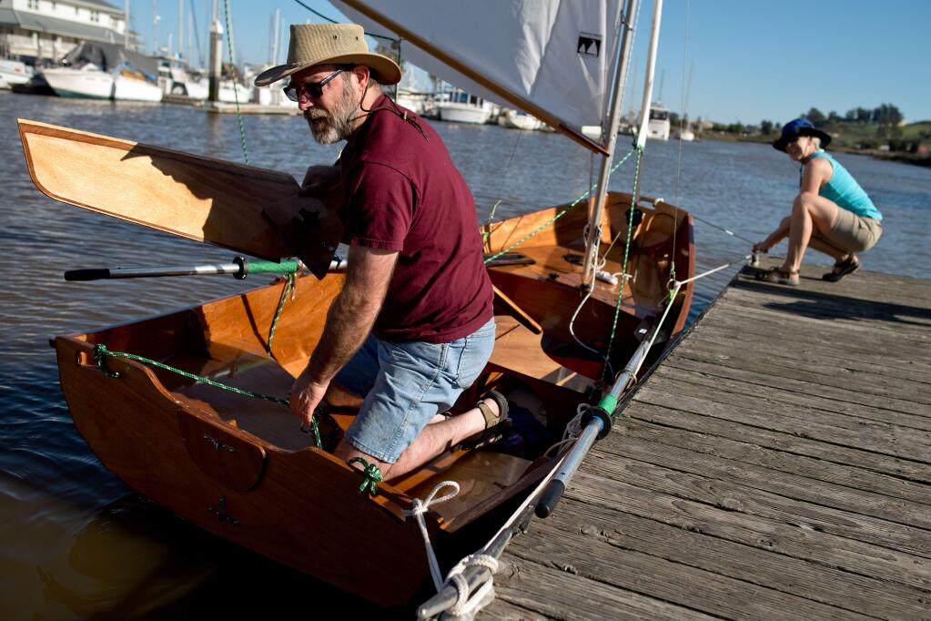 Alan Fulkerson pulls up the rudder to his 12-foot sailboat while his wife Anne Schenk holds the boat steady at the Petaluma Marina boat ramp in Petaluma, Calif., on March 15, 2014. (Alvin Jornada / The Press Democrat)