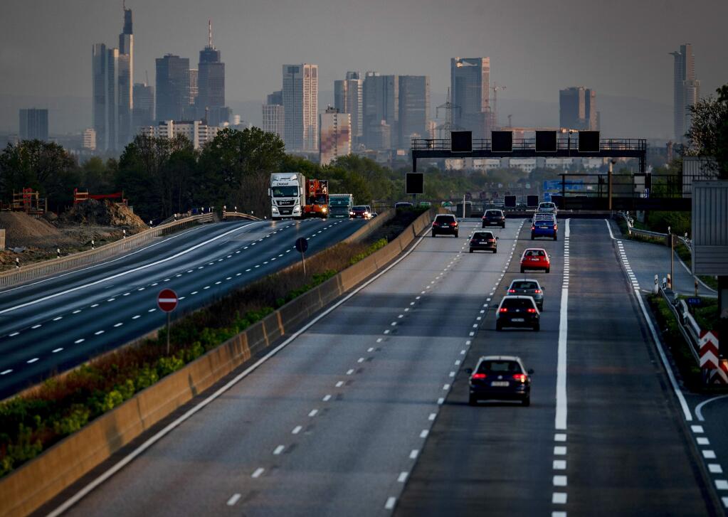 In this April 16, 2020, a few cars and trucks drive on the usually very crowded main highway around Frankfurt, Germany, that is seen in the background. As the restrictions to avoid the spreading of the coronavirus are eased, Chancellor Angela Merkel has pointed to South Korea as an example of how Germany will have to improve measures to “get ahead” of the pandemic with more testing and tracking of cases so that the rate of infections can be slowed. (AP Photo/Michael Probst)