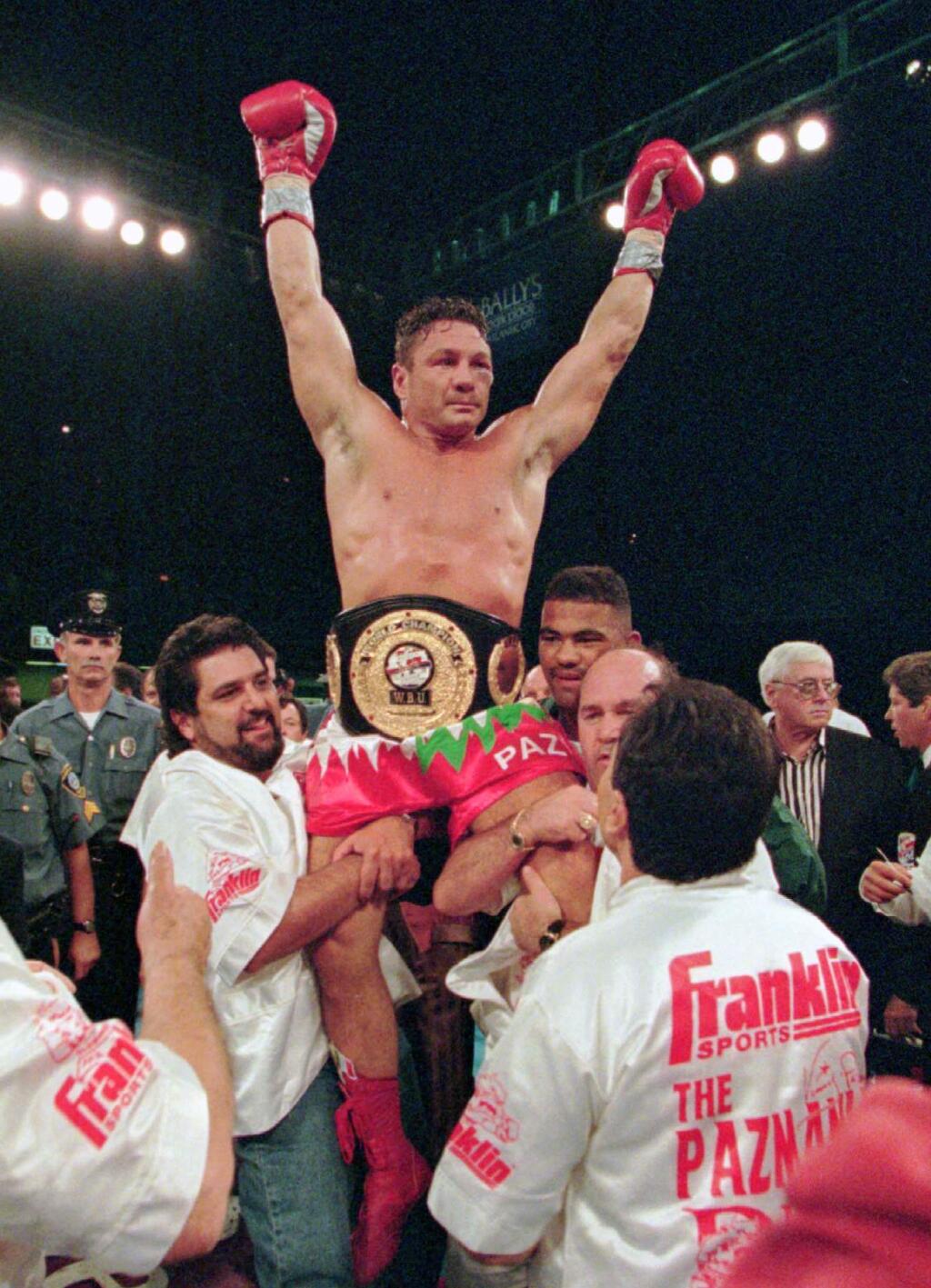 FILE - In this Aug. 23, 1996 file photo, boxer Vinny Pazienza, of Providence, R.I., is lifted up after winning a 12 round WBU super middleweight title bout against Dana Rosenblatt in Atlantic City, N.J. A new film, 'Bleed For This,' based on Pazienza's life, opens November 18. (AP Photo/Bill Borrelli, File)