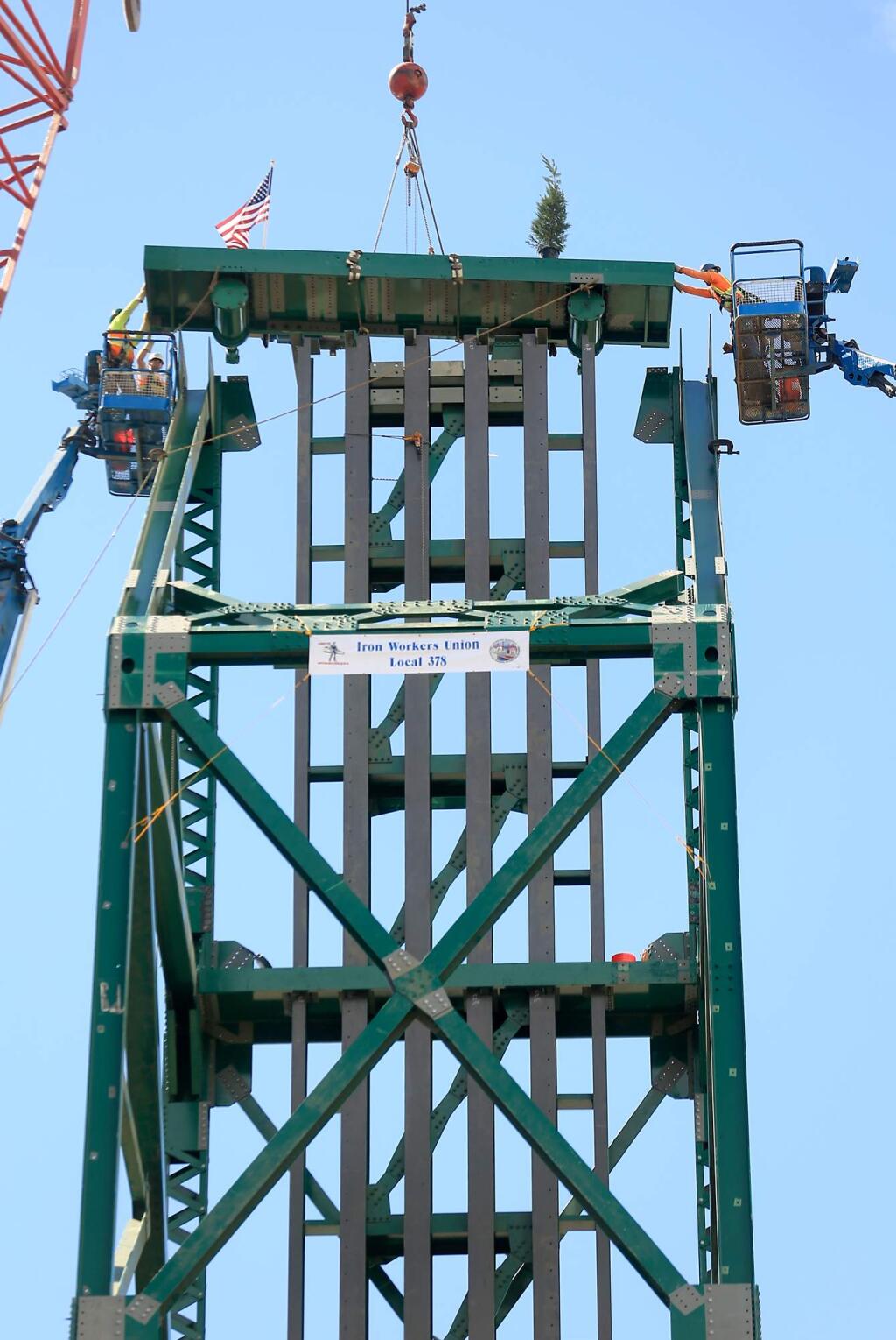 Joe Hackenkamp and Steve Moretti, left and Mike Perry, right secure the final piece of the Haystack Landing bridge, Tuesday Aug. 11, 2015 in Petaluma . (Kent Porter / Press Democrat) 2015