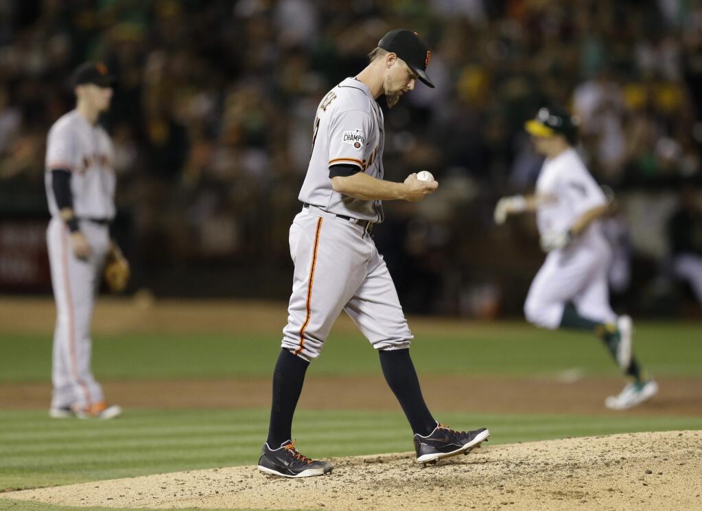 San Francisco Giants pitcher Mike Leake, center, waits for Oakland Athletics' Billy Burns, right, to run the bases after Burns hit a two run home run in the third inning Friday, Sept. 25, 2015, in Oakland. (AP Photo/Ben Margot)