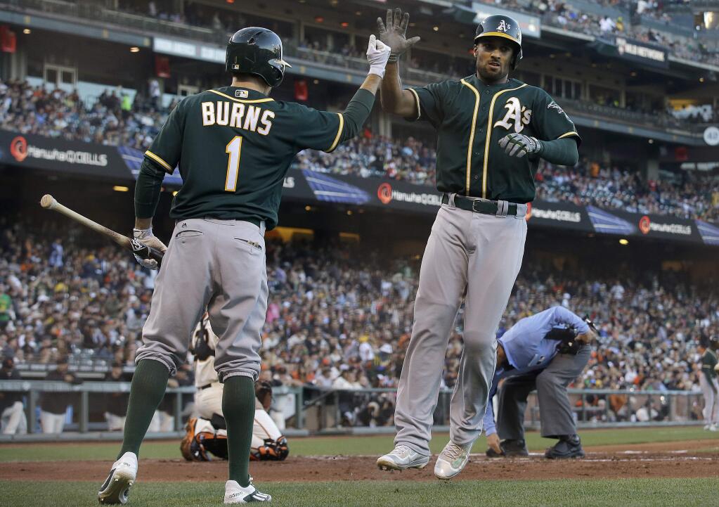Oakland Athletics' Marcus Semien, right, is congratulated by Billy Burns after hitting a three-run home run off of San Francisco Giants pitcher Jeff Samardzija during the second inning of a baseball game in San Francisco, Monday, June 27, 2016. (AP Photo/Jeff Chiu)
