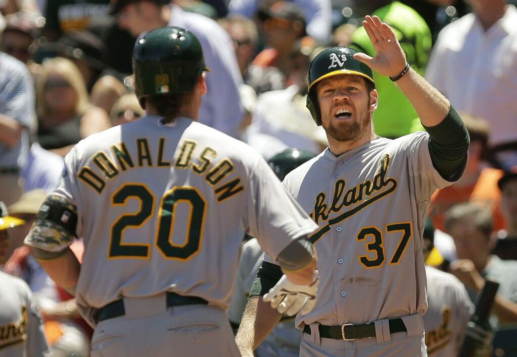 Brandon Moss, right, congratulates Josh Donaldson after Donaldson hit a two-run homer in a 2014 game with the Oakland A's. (Conner Jay/The Press Democrat)