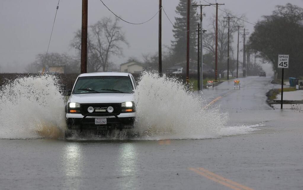 A truck navigates through water along Lytton Station Road, which was closed due to flooding, in Healdsburg on Tuesday, February 26, 2019. (Christopher Chung/ The Press Democrat)