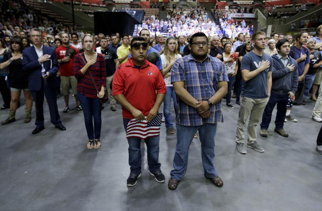 Supporters stand for the pledge of allegiance prior to Republican presidential candidate Donald Trump speaking at a rally, Friday, May 27, 2016, in Fresno, Calif. (AP Photo/Chris Carlson)