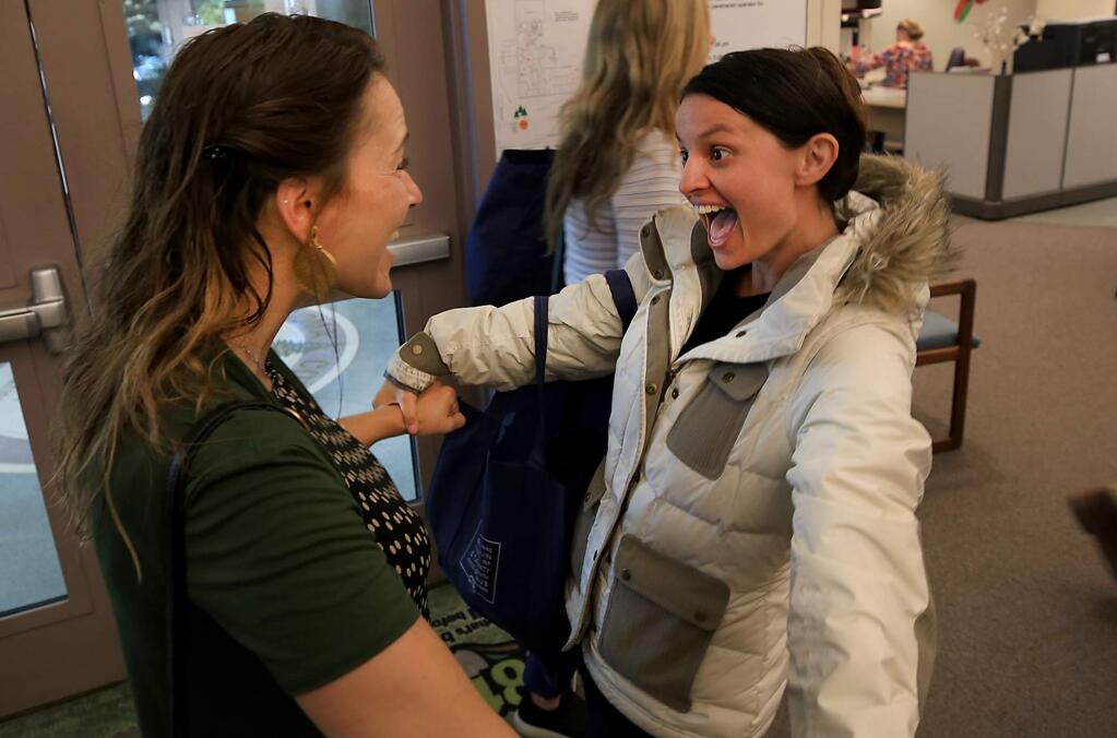 Karen Kohley of Santa Rosa's Flora Cal Farms, right, gets a congratulatory greeting from Tawnie Logan, the former executive director of the Sonoma County Growers Alliance after Kohley completed her permit for her marijuana business Wednesday July 5, 2017 at the Sonoma County Permit and Resource Management Department in Santa Rosa. (Kent Porter / Press Democrat) 2017