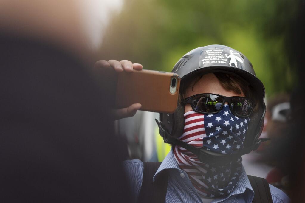 A white nationalist holds his phone while marching to Lafayette Square during the 'Unite the Right 2' rally in Washington, Sunday, Aug. 12, 2018. (Craig Hudson/Charleston Gazette-Mail via AP)