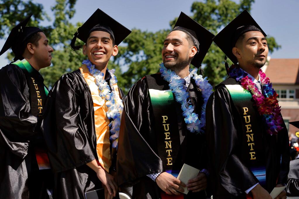 SRJC students, from right, Jimmy Novella, Diego Ortiz Carreno, Rodrigo Pacheco, and Oswaldo Angeles look around for friends and family in the audience as they line up to receive their diplomas during the 100th annual Santa Rosa Junior College commencement ceremony, in Santa Rosa, California, on Saturday, May 25, 2019. (Alvin Jornada / The Press Democrat)