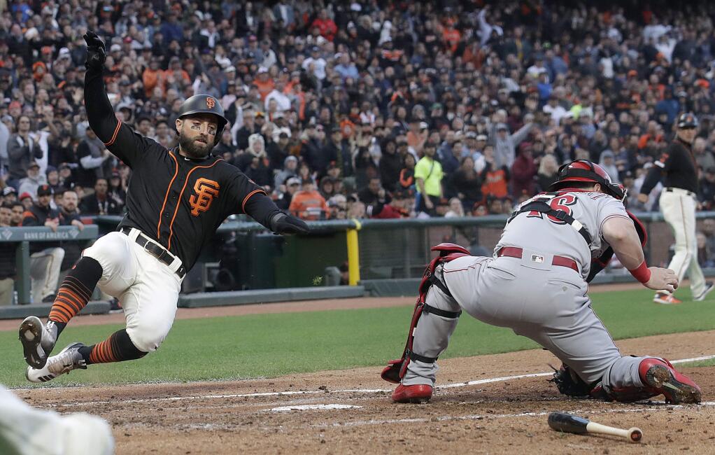 San Francisco Giants' Kevin Pillar, left, slides past Cincinnati Reds catcher Tucker Barnhart to score a run during the fourth inning of a baseball game in San Francisco, Saturday, May 11, 2019. (AP Photo/Jeff Chiu)