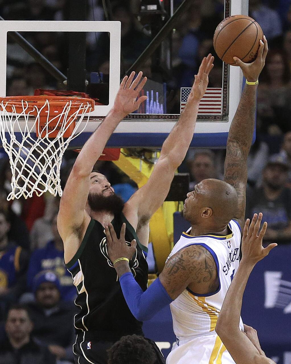Golden State Warriors' Marreese Speights, right, shoots over Milwaukee Bucks' Miles Plumlee during the first half of an NBA basketball game Friday, Dec. 18, 2015, in Oakland, Calif. (AP Photo/Ben Margot)