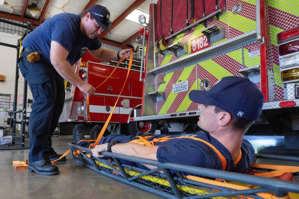 Gold Ridge intern firefighter Alex Gardner, left, trains with firefighter Konner Andrade on how to a patient into a Stokes basket, which is used rescue situations, at Gold Ridge Fire Protection District Station #2, in the Twin Hills community of Sebastopol, California, on Wednesday, October 9, 2019. (Alvin Jornada / The Press Democrat)