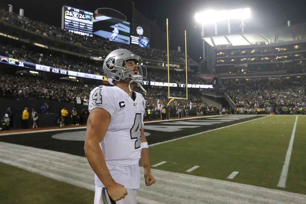 Oakland Raiders quarterback Derek Carr celebrates after the Raiders defeated the Los Angeles Chargers 26-24 in Oakland, Thursday, Nov. 7, 2019. (AP Photo/D. Ross Cameron)