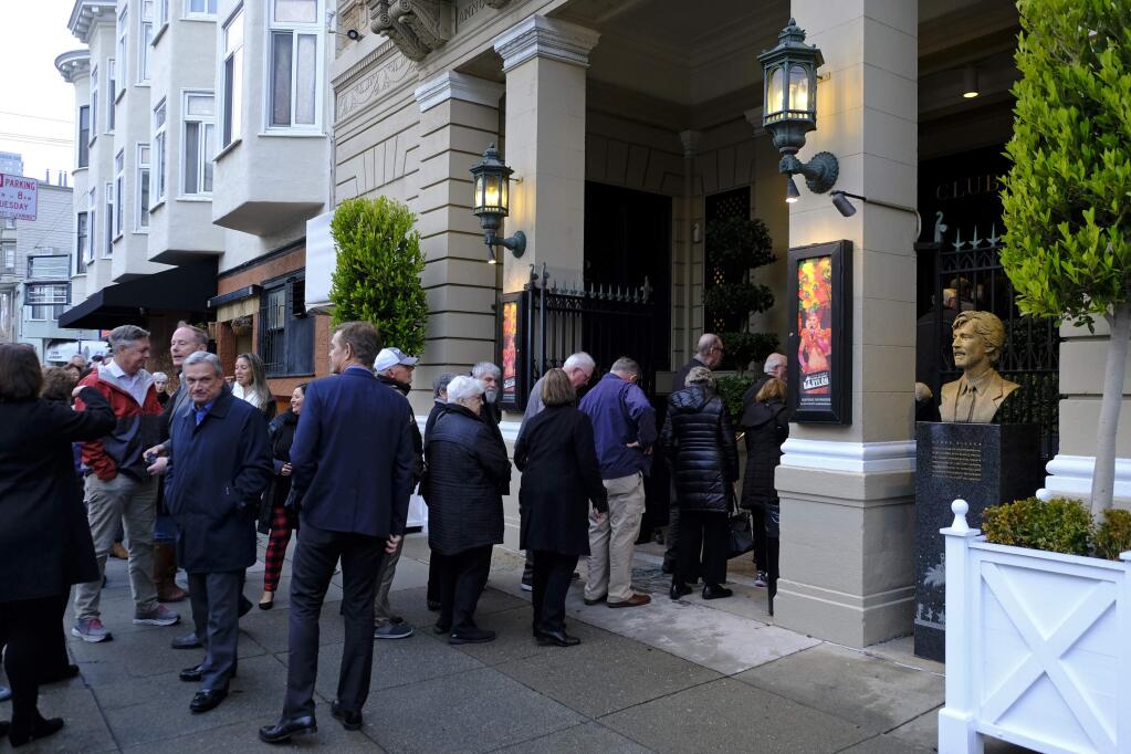 In this Wednesday, Dec. 4, 2019, people line up outside the Club Fugazi to see one of the last performances of the musical 'Beach Blanket Babylon' in San Francisco. The final performance of the small campy San Francisco show is set for New Year's Eve. (AP Photo/Eric Risberg)