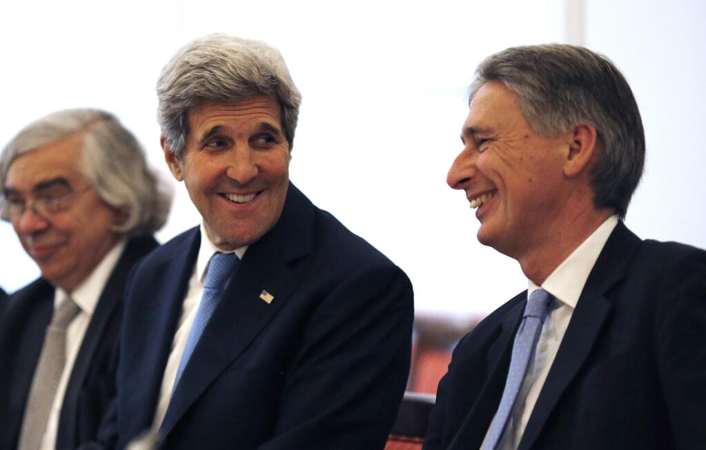 U.S. Secretary of State John Kerry, left, talks with British Foreign Secretary Philip Hammond, right, as they meet with foreign ministers from China, Germany and France at an hotel in Vienna, Austria Monday, July 6, 2015. Iran's foreign minister said on Monday some differences still remained between Iran and six powers over the country's disputed nuclear programme ahead of Tuesday's deadline for a final agreement to end a 12-year-old dispute. (Carlos Barria/Pool Photo via AP)