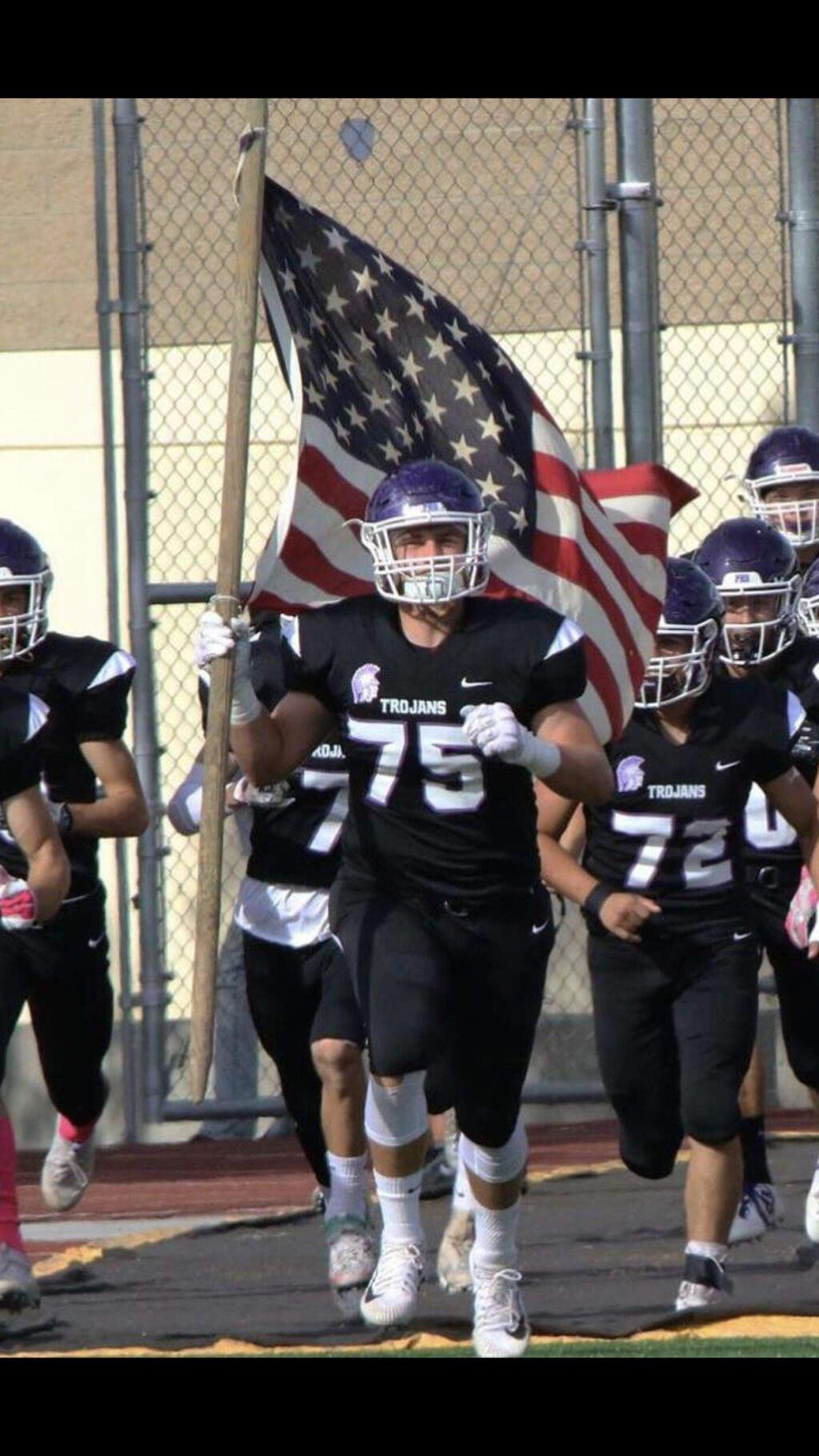 SUBMITTED PHOTONick Siembieda (No. 75) leads Petaluma High's Trojans onto the field. The senior two-way All-League lineman has been nominated to four military service academies.