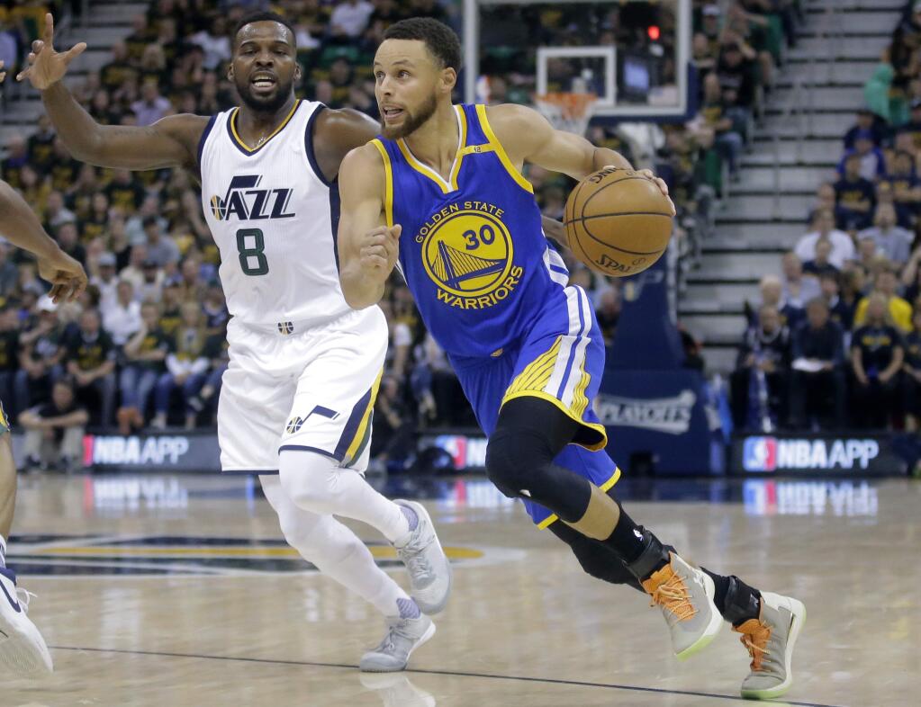 In this May 8, 2017 file photo, Golden State Warriors guard Stephen Curry (30) drives as Utah Jazz guard Shelvin Mack (8) defends in the first half of Game 4 of their second-round playoff series in Salt Lake City. (AP Photo/Rick Bowmer, File)