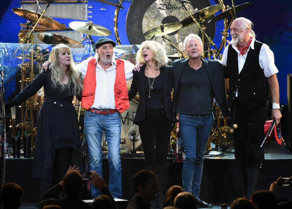 FILE - In this Jan. 26, 2018 file photo, Fleetwood Mac band members, from left, Stevie Nicks, John McVie, Christine McVie, Lindsey Buckingham and Mick Fleetwood appear at the 2018 MusiCares Person of the Year tribute honoring Fleetwood Mac in New York. Buckingham is suing his bandmates in Fleetwood Mac for kicking him off the band's new tour. In the suit, the Hollywood Reporter says the guitarist and songwriter is seeking his share of the tour because he says he still wants and is able to perform. The more than 50-city tour starts Friday, Oct. 12 in Nebraska, with Mike Campbell and Neil Finn replacing Buckingham. (Photo by Evan Agostini/Invision/AP, File)