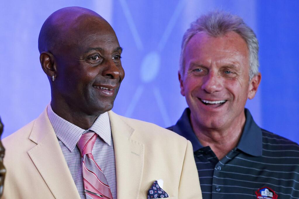 Pro Football Hall of Fame receiver Jerry Rice, left, and quarterback Joe Montana join former NFL owner Edward J. DeBartolo Jr.as he poses with his bust during an induction ceremony at the Pro Football Hall of Fame Saturday, Aug. 6, 2016, in Canton, Ohio. (AP Photo/Ron Schwane)