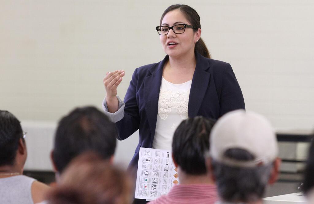 Lizette Mata of the Department of Motor Vehicles addresses a group of people during a community forum held at Cook Middle School in Santa Rosa, Tuesday, Aug. 19, 2014. (CRISTA JEREMIASON/ PD)