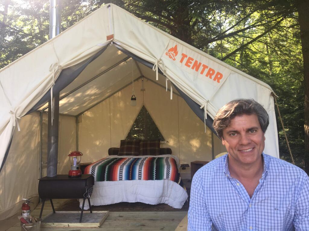 In this Friday, June 29, 2018, photo, Michael D'Agostino, CEO of Tentrr, sits in front of a tent at one of the startup's campsites on private land in upstate New York. D'Agostino says Tentrr is like Airbnb or Uber for the great outdoors, providing a platform for landowners to share secluded and scenic sites for camping. (AP Photo/Mary Esch)