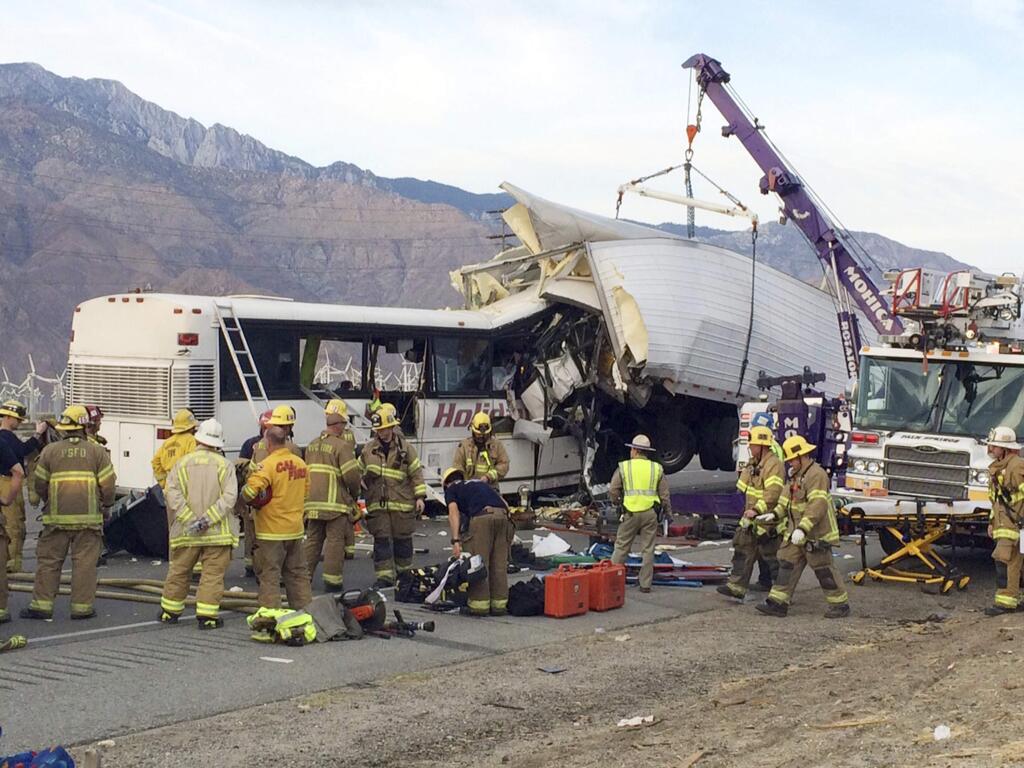 Emergency personnel work the scene where a tour bus crashed into the rear of a semi-truck on westbound Interstate 10, just north of the desert resort town of Palm Springs, in Desert Hot Springs, Calif., Sunday, Oct. 23, 2016. Multiple deaths and injuries were reported. (Colin Atagi/The Desert Sun via AP)