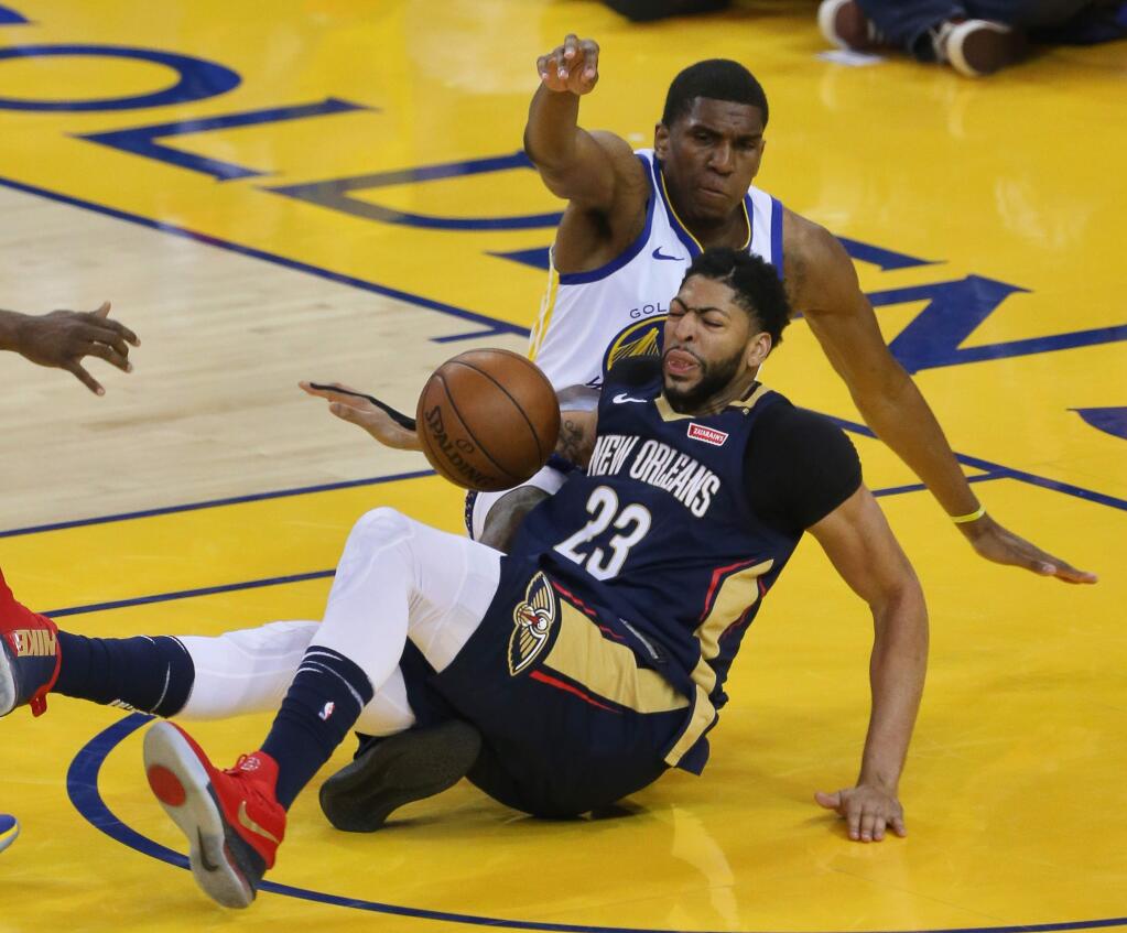 New Orleans Pelicans center Anthony Davis and Golden State Warriors forward Kevon Looney fall to the floor during their game in Oakland on Tuesday, May 8, 2018. (Christopher Chung / The Press Democrat)