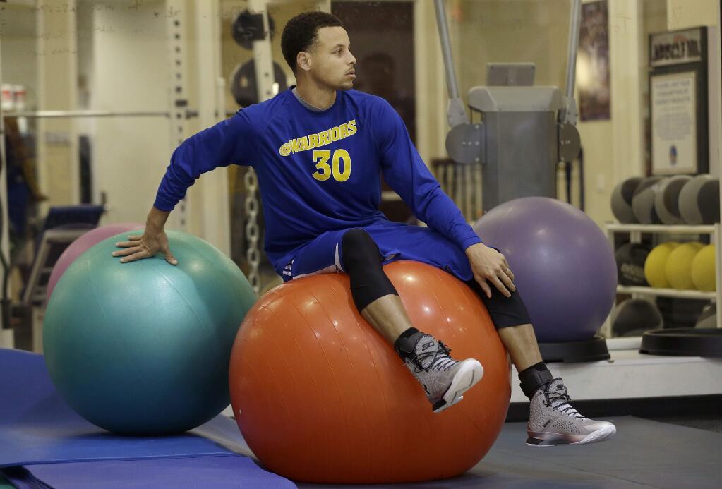 Golden State Warriors guard Stephen Curry (30) sits on an exercise ball during practice in Oakland, Friday, April 17, 2015.The Warriors will to play the New Orleans Pelicans in a first-round playoff series starting on Saturday. (AP Photo/Jeff Chiu)