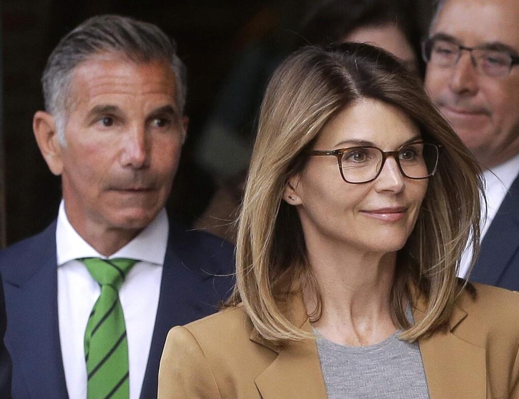 FILE - In this April 3, 2019, file photo, actress Lori Loughlin, front, and her husband, clothing designer Mossimo Giannulli, left, depart federal court in Boston. 'Full House' actress Loughlin, Giannulli and other prominent parents told a judge Wednesday, March 25, 2020, that he should dismiss charges against them in the college admissions bribery case, accusing prosecutors of 'extraordinary' misconduct. (AP Photo/Steven Senne, File)