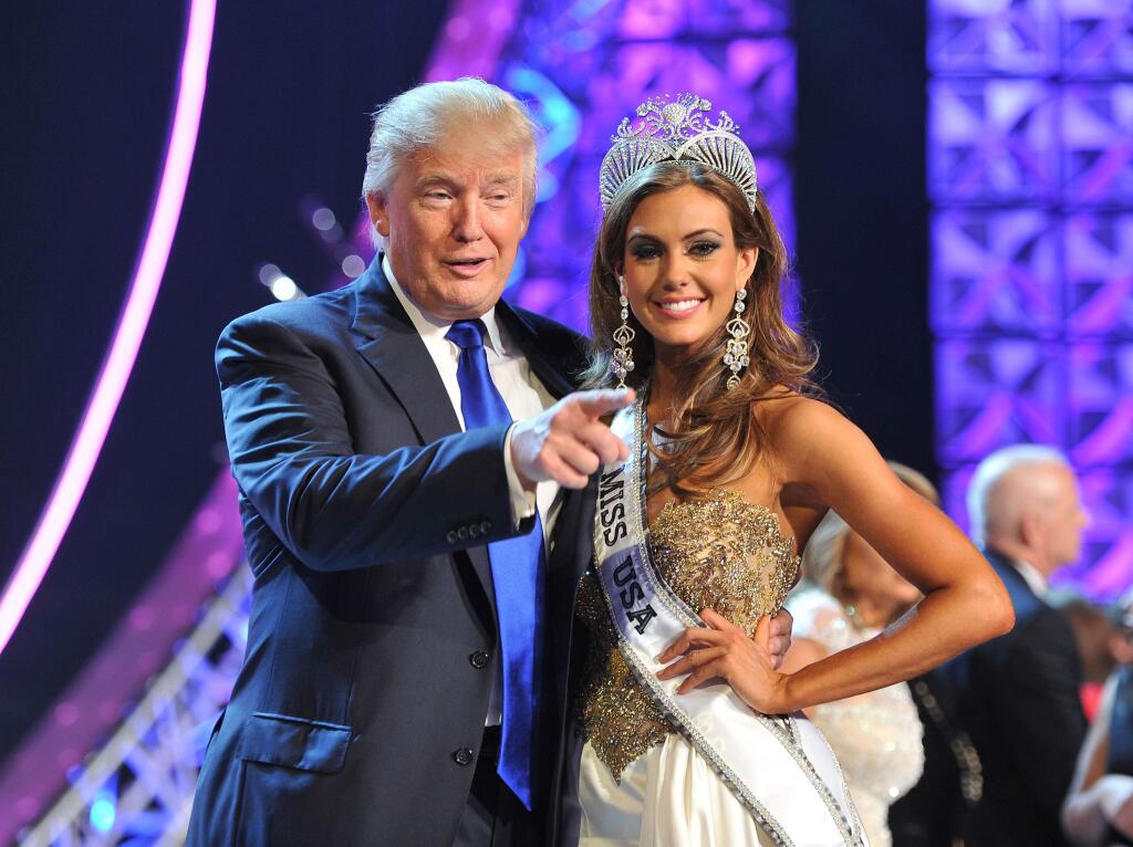 FILE - In this June 16, 2013 file photo, Donald Trump, left, and Miss Connecticut USA Erin Brady pose onstage after Brady won the 2013 Miss USA pageant in Las Vegas, Nev. Univision says it is dropping the Miss USA Pageant and says it will cut all business ties with Donald Trump over comments he made about Mexican immigrants. The network said Thursday, June 25, 2015, it will not air the pageant on July 12, as previously scheduled, and has ended its business relationship with the Miss Universe Organization due to what it called 'insulting remarks about Mexican immigrants' by Trump, a part owner. (AP Photo/Jeff Bottari, File)
