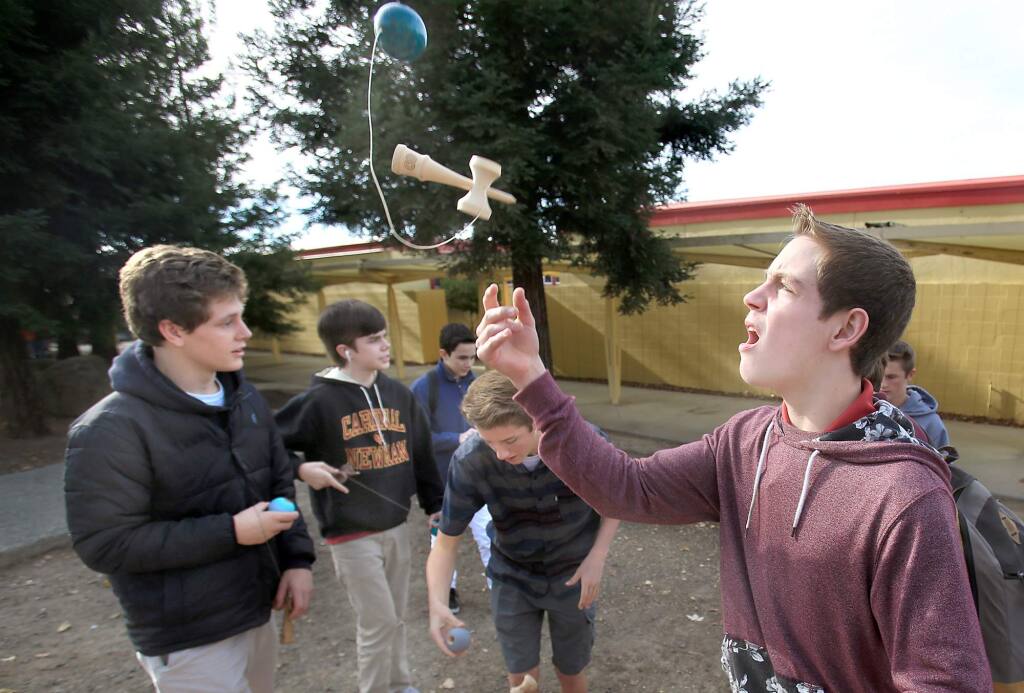 Cardinal Newman student Carlin Hornbostel, right, joins his classmates, from left. Kyle Smith , Nick Lyttle, Dylan Levinson and Nick Hernandez practice their skills in kendama, during a school break, Wednesday Nov. 18, 2015. (Kent Porter / Press Democrat) 2015