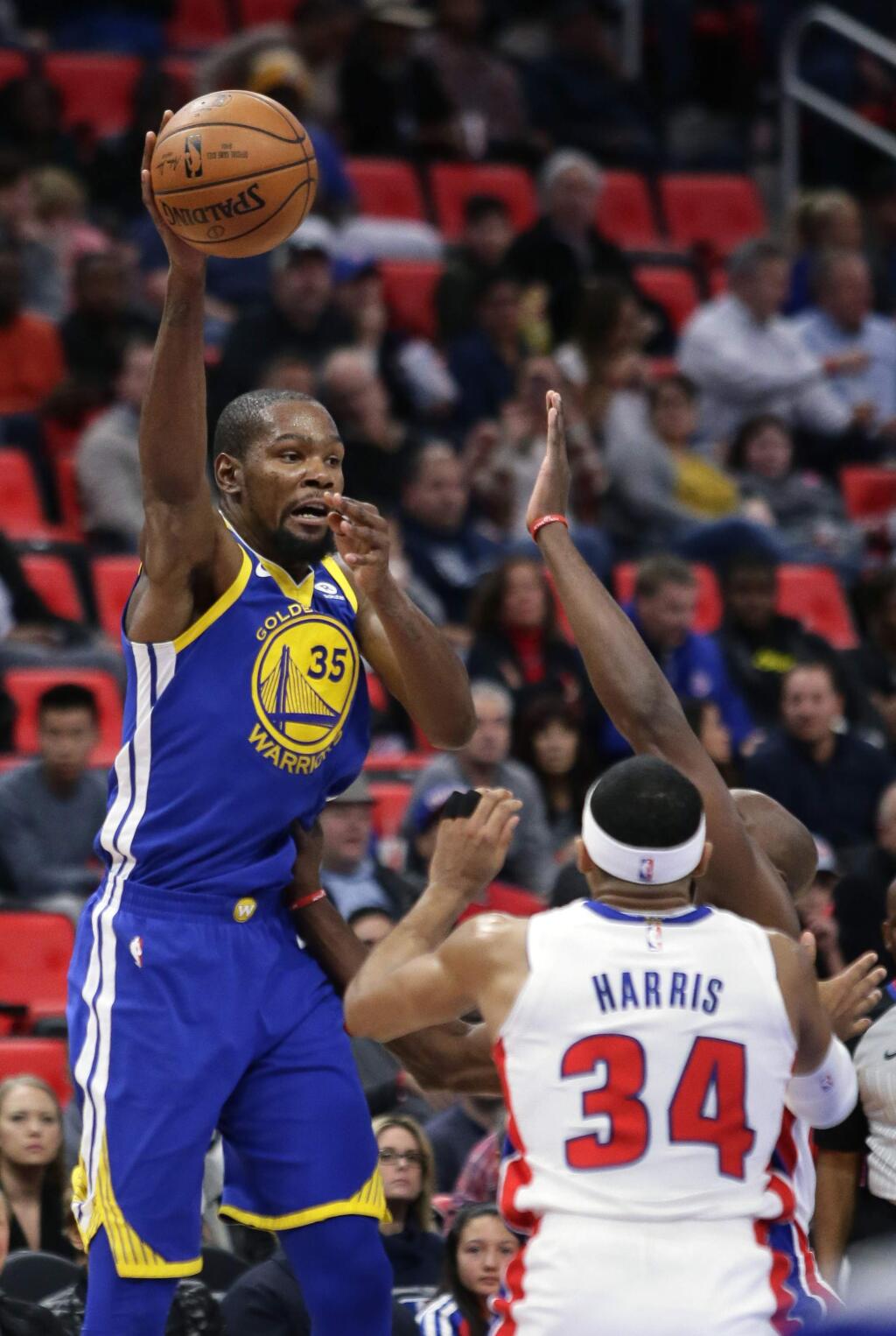 Golden State Warriors forward Kevin Durant (35) passes the ball over Detroit Pistons forward Tobias Harris (34) during the first quarter of an NBA basketball game Friday, Dec. 8, 2017, in Detroit. (AP Photo/Duane Burleson)
