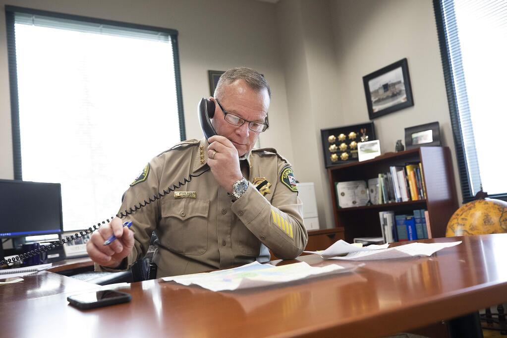 Sonoma County Sheriff Mark Essick spent much of Monday on the phone with local radio stations explaining when evacuees will be allowed back in their homes. (photo by John Burgess/The Press Democrat)