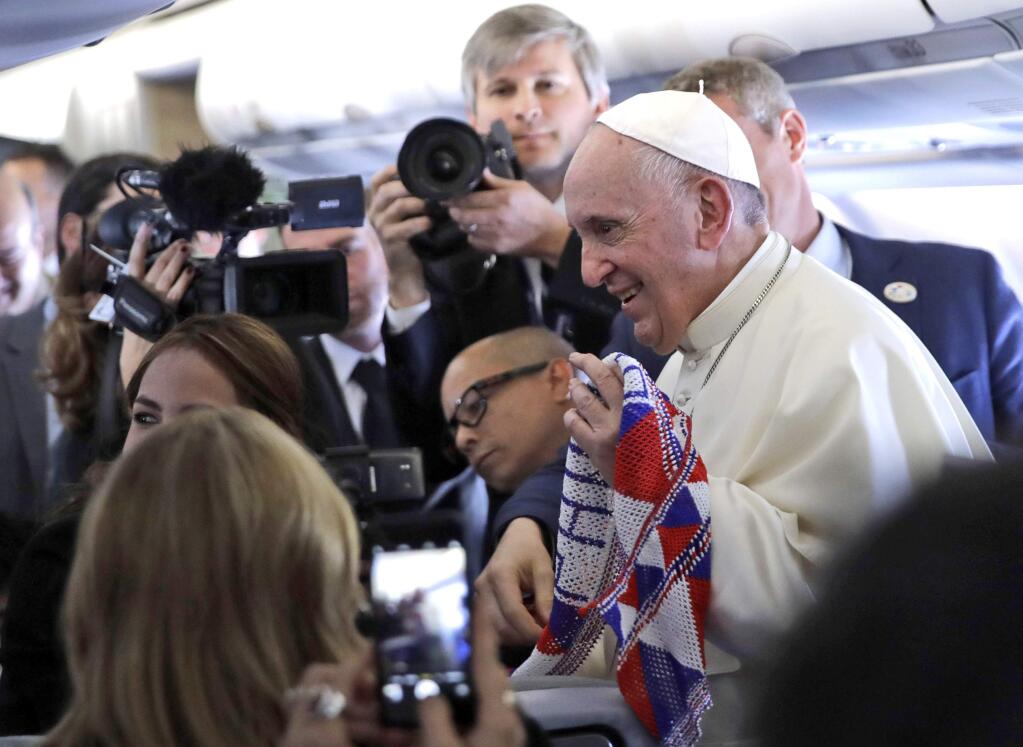 Pope Francis is presented with a Panama scarf by journalists during the flight from Rome to Panama City, Wednesday, Jan. 23, 2019. (AP Photo/Alessandra Tarantino)