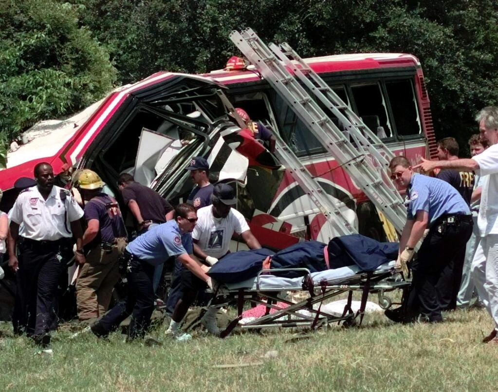 FILE - In this May 9, 1999, file photo, emergency workers remove the body of one of the victims of a bus crash in New Orleans, where a chartered bus carrying members of a casino club on a Mother's Day gambling excursion ran off a highway, killing 22 people, in one of the nation's deadliest crashes. A limousine carrying 18 people crashed Saturday, Oct. 6, 2018, in upstate New York, killing all the occupants and two pedestrians, making it among the nation's deadliest ground-traffic accidents. (AP Photo/Bill Haber, File)
