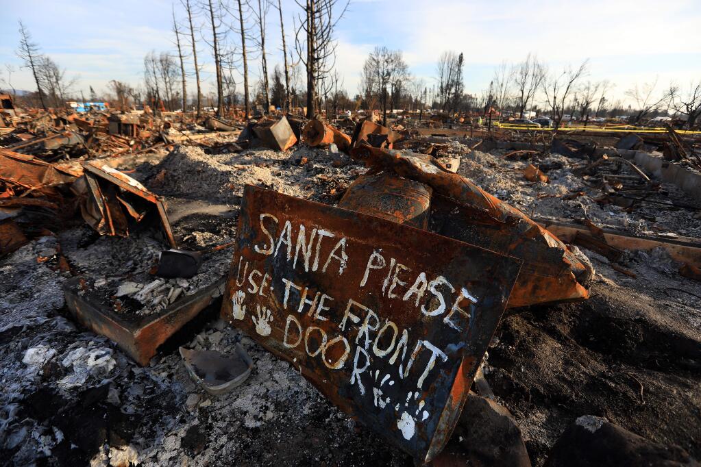 A sign painted on debris in Coffey Park directs Santa at a burned home in Coffey Park. (Kent Porter / The Press Democrat)