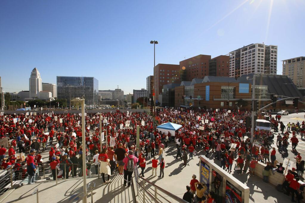 Thousands of teachers who may go on strike against the nation's second-largest school district next month rally in downtown Los Angeles Saturday, Dec. 15, 2018. The teacher's union is locked in a contract dispute with the Los Angeles Unified School District and the teachers are threatening to strike for the first time in nearly 30 years next month. (AP Photo/Damian Dovarganes)