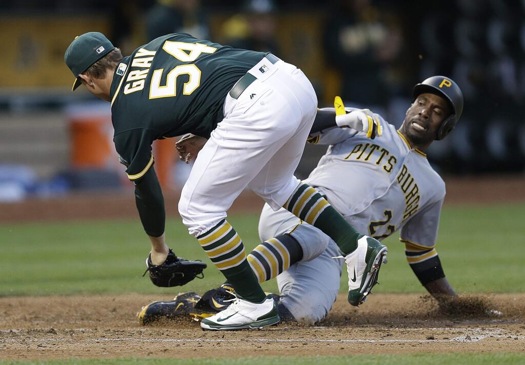 Pittsburgh Pirates' Andrew McCutchen, right, slides to score on a wild pitch from Oakland Athletics pitcher Sonny Gray in the fourth inning Friday, July 1, 2016, in Oakland. (AP Photo/Ben Margot)