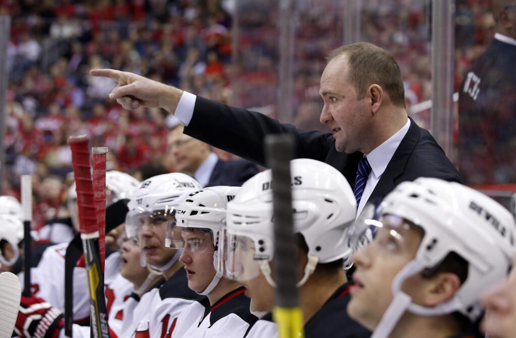 FILE - In this Dec. 21, 2013, file photo, then-New Jersey Devils head coach Peter DeBoer directs his team in the first period of an NHL hockey game against the Washington Capitals in Washington. The San Jose Sharks will hire Peter DeBoer as their new head coach. A person familiar with the search said Wednesday, May 27, 2015, that DeBoer will be formally introduced later this week. The person spoke on condition of anonymity because the team had not announced the hire yet. ESPN first reported the move.(AP Photo/Alex Brandon, File)