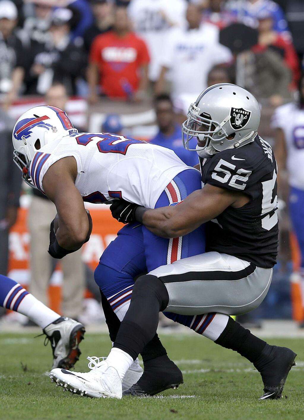 Oakland Raiders outside linebacker Khalil Mack (52) tackles Buffalo Bills running back Fred Jackson (22) during the first quarter of a game in Oakland, Sunday, Dec. 21, 2014. (AP Photo/Jeff Chiu)