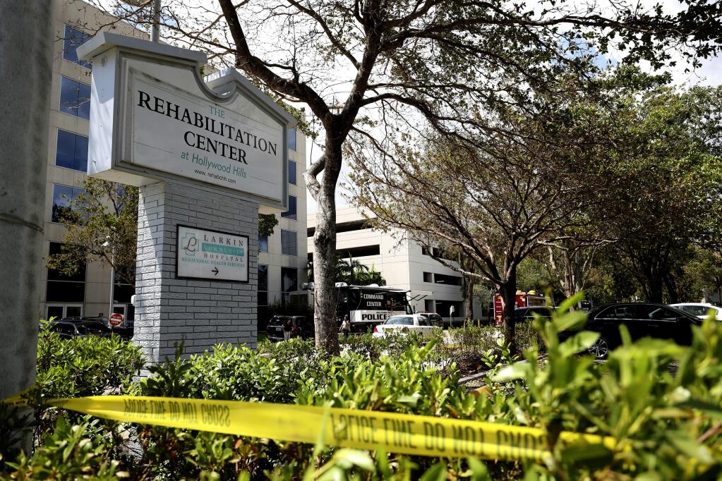 FILE- This Sept. 13, 2017, file photo, police surround the Rehabilitation Center in Hollywood Hills, Fla. Nine elderly patients died after being kept inside a nursing home that turned into a sweatbox when Hurricane Irma knocked out its air conditioning for three days, even though just across the street was a fully functioning and cooled hospital. Still, even with those facts, it's far from clear whether the deaths will result in a criminal prosecution. (John McCall/South Florida Sun-Sentinel via AP, File)