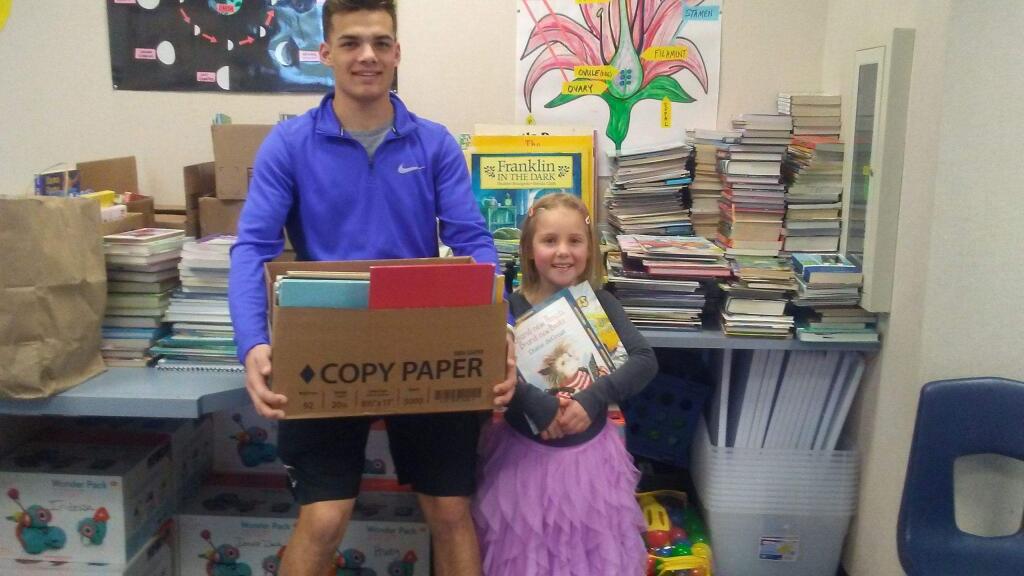 SUBMITTED PHOTOCasa Grande senior Jadon Bosarge gets help from Paradise resident Hayden Appel, 6, in book collection at Grant School. Bosarge's senior project was collecting books donated to Paradise children.