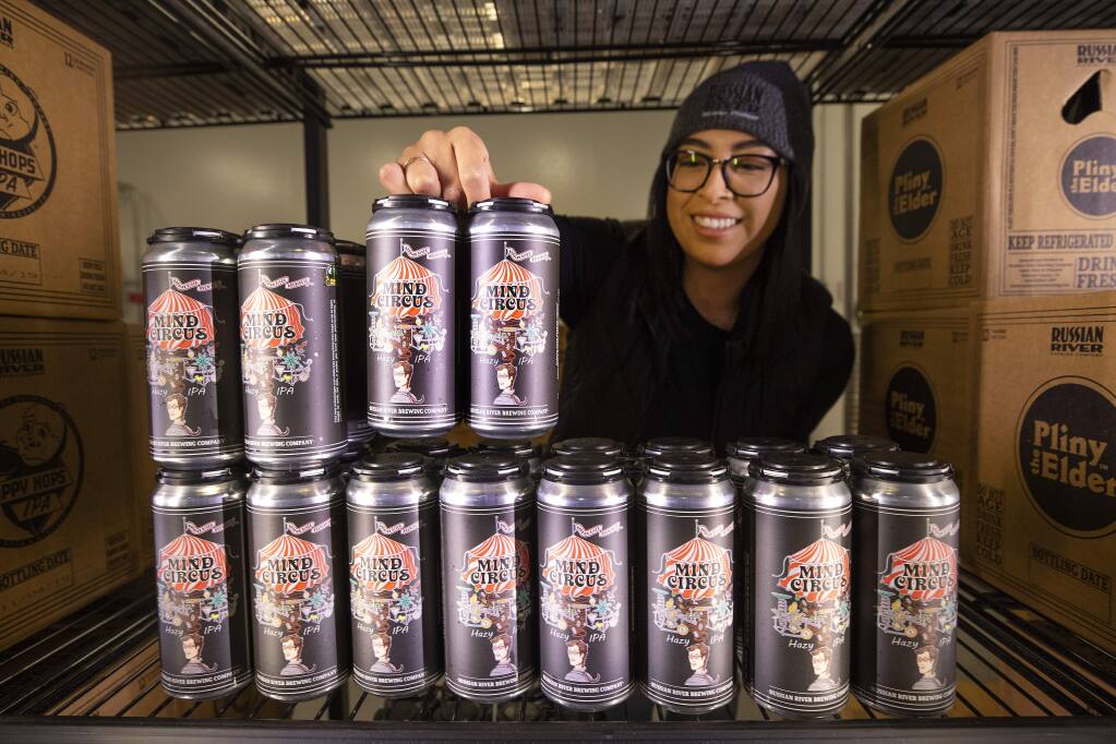 Ari Saldana restocks the new Russian River Mind Circus hazy India pale ale at their Windsor store. The IPA is the first canned beer for Russian River and only available at their two brewpubs. (photo by John Burgess/The Press Democrat)