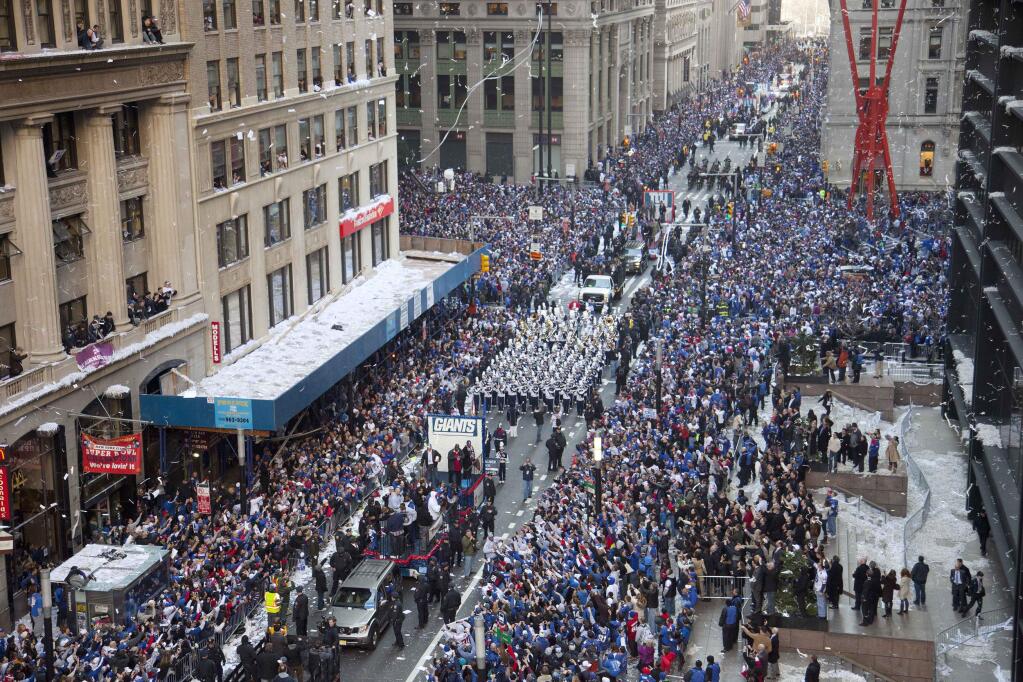 FILE - In this Feb. 7, 2012, file photo, the New York Giants get a ticker tape parade as they head up the Canyon of Heroes in New York to celebrate the Giants' win against the New England Patriots in the Super Bowl. On Friday July 10, 2015, the U.S. women's soccer team will celebrate winning the FIFA Women's World Cup soccer championship with a ticker-tape parade along the same route on lower Broadway where they will be the first national team since 1984 and the first all-female team ever to be honored with the iconic parade. (AP Photo/Mark Lennihan, File)