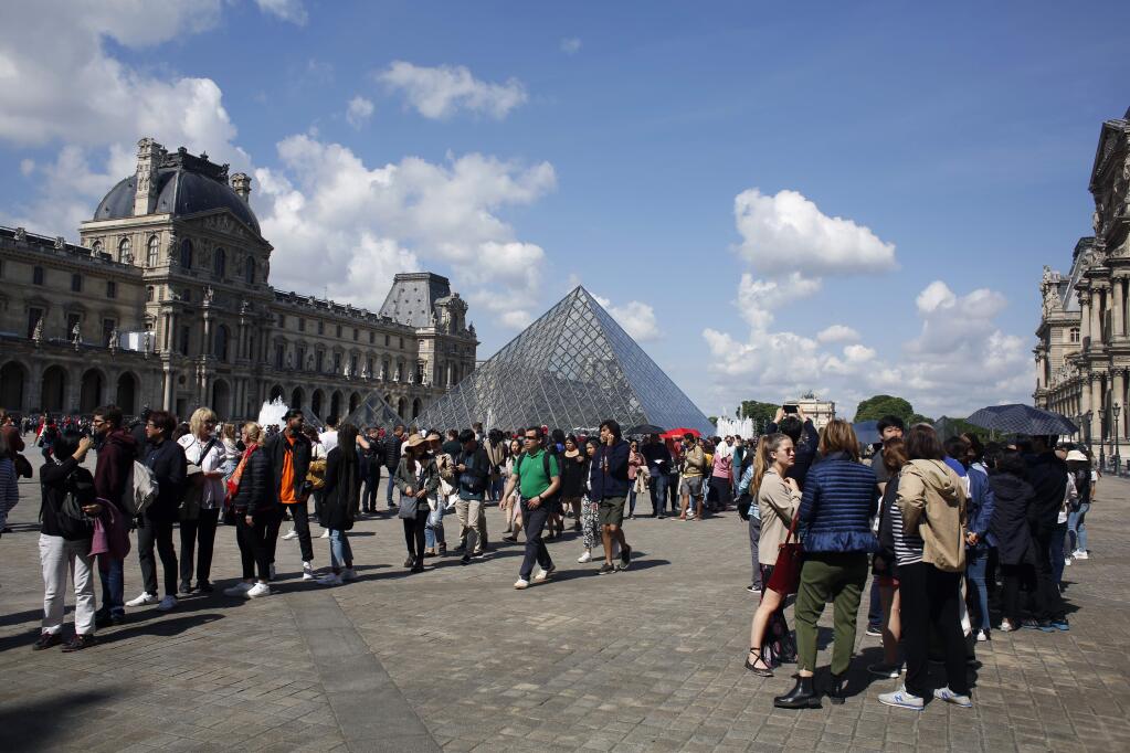 Tourists wait in line to visit the Louvre museum in Paris, Wednesday, May, 29, 2019. (AP Photo/Thibault Camus)