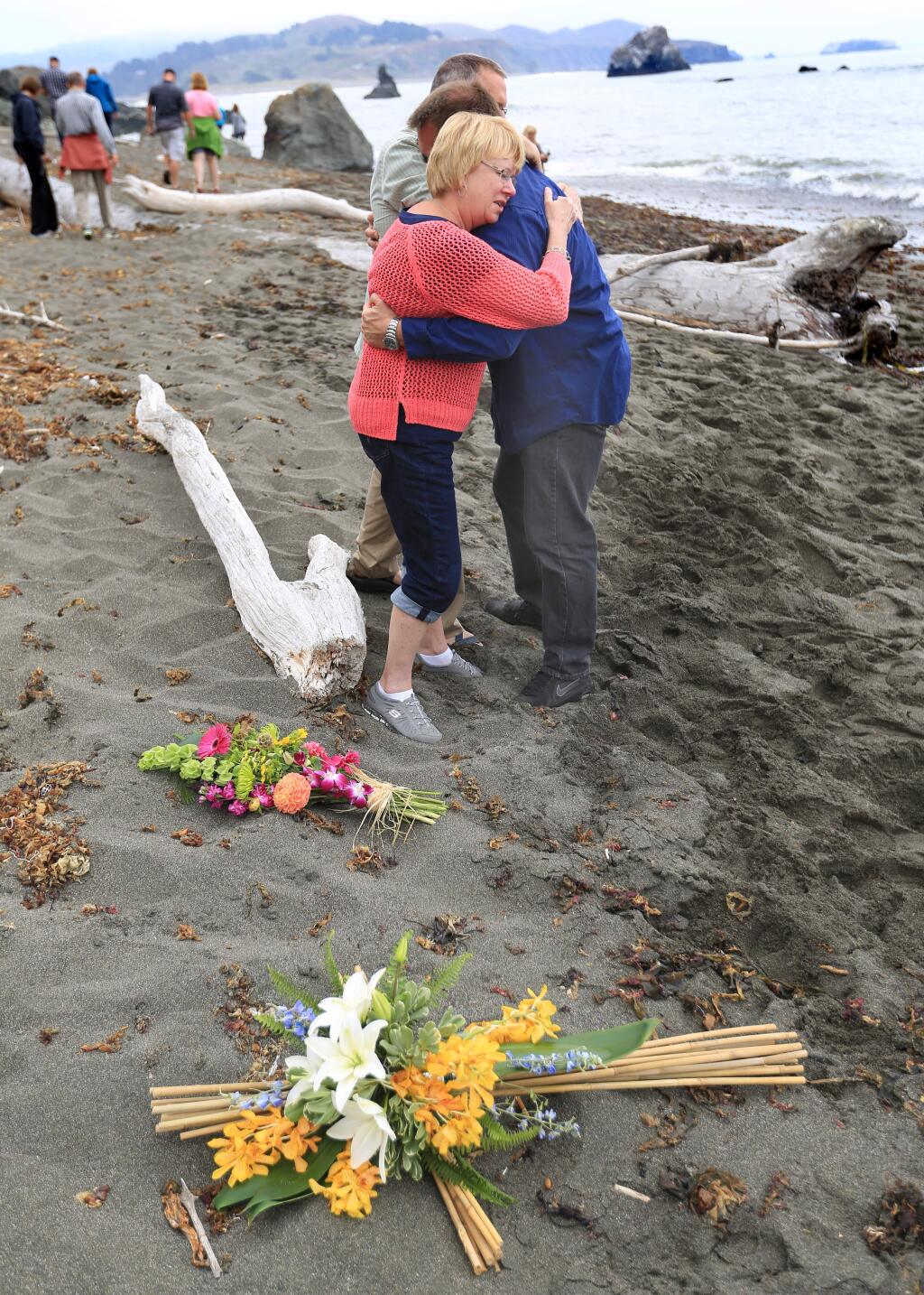 Kathy and Chris Cutshall embrace Sgt. Tim Duke of the Sonoma County Sheriff's Department, right, Friday, Aug. 15, 2014 at the site of their daughter Lindsay Cutshall's death with Jason Allen on Fish Head Beach just north of Jenner. The two were slain 10 years ago, but the crime remains unsolved. (Kent Porter / Press Democrat)